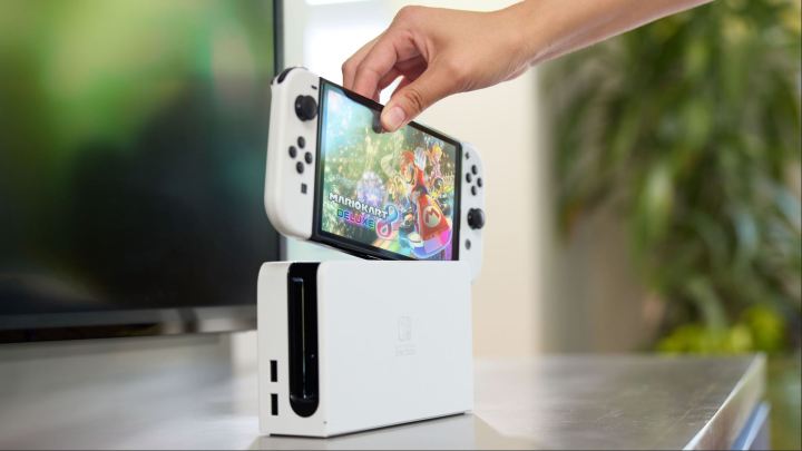 2024 Gaming Report Card: How did Playstation, Xbox, and Nintendo rent? 3 One picks up a nintendo switch OLED model.