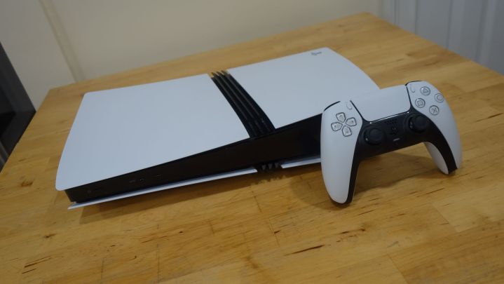 A PS5 Pro sits on a table with a dualsense.
