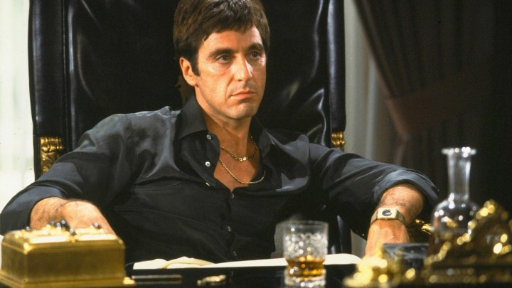 10 Best Film Remake, Rank of All Time, Rank 9 Al Pino was sitting at his desk in a prestigious scene as Tony Montana in the scarfs.